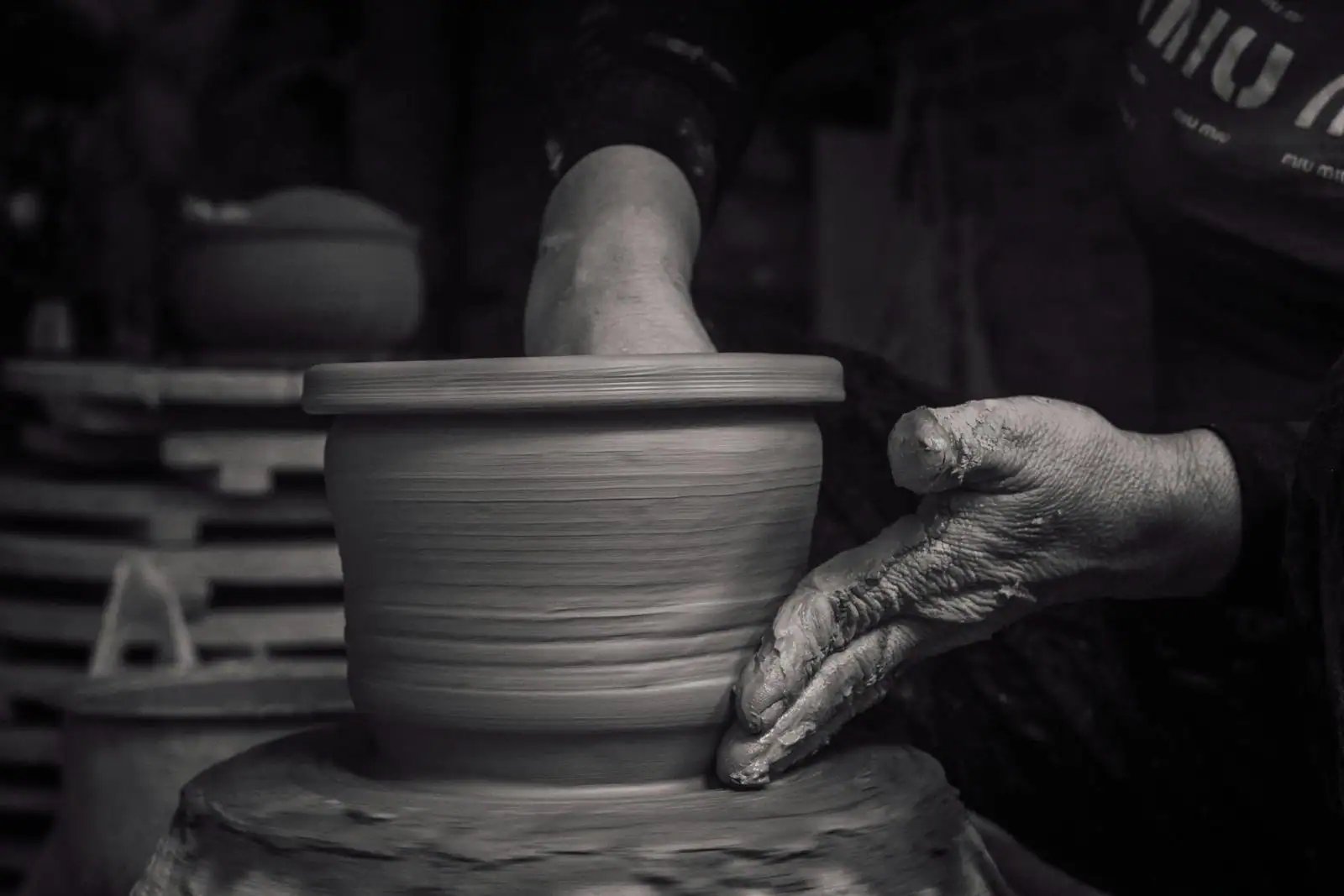 Atelier créatif à Toulouse avec mains qui modèlent de la poterie sur une table de travail