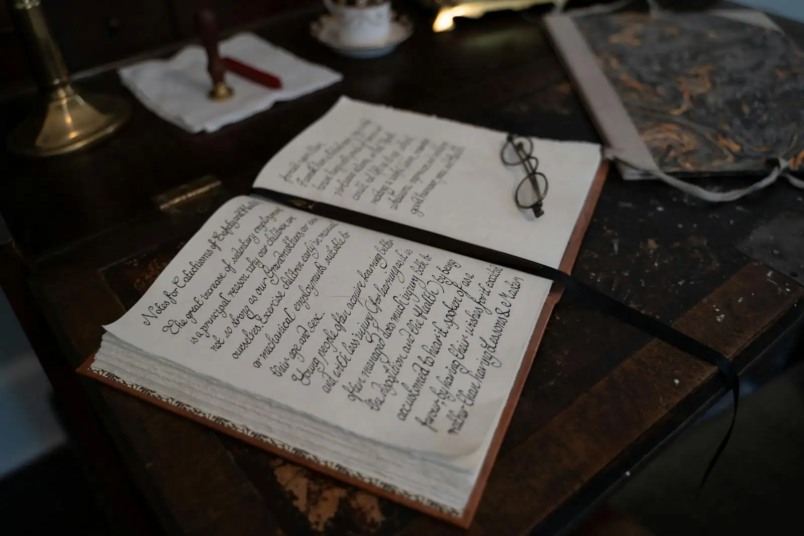 Carnet ouvert avec stylo et lampe douce, ambiance de réflexion sur une rupture amoureuse