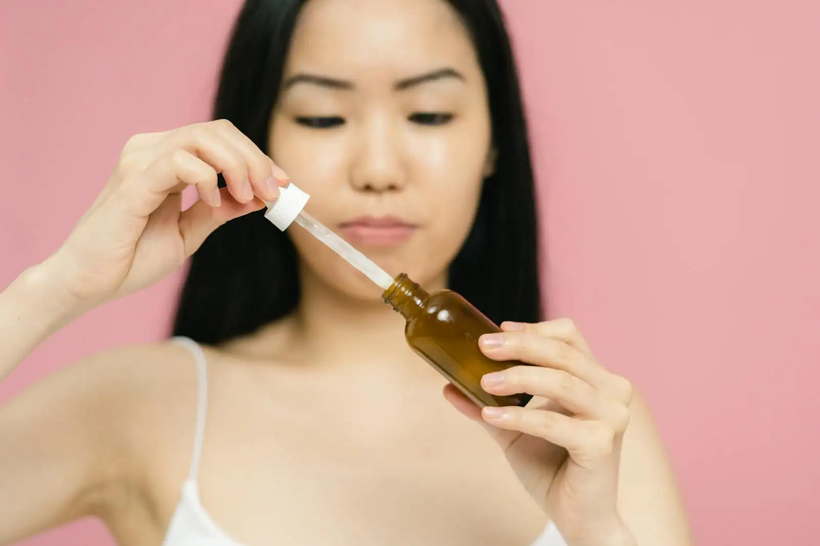 Flacon de sérum anti-tache et soin visage posés sur une coiffeuse en marbre, lumière douce du matin
