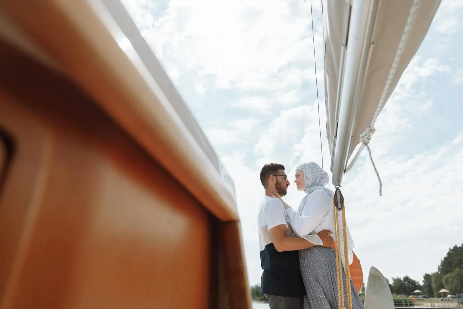 Couple complice échangeant un regard sur le pont d'un bateau au coucher du soleil