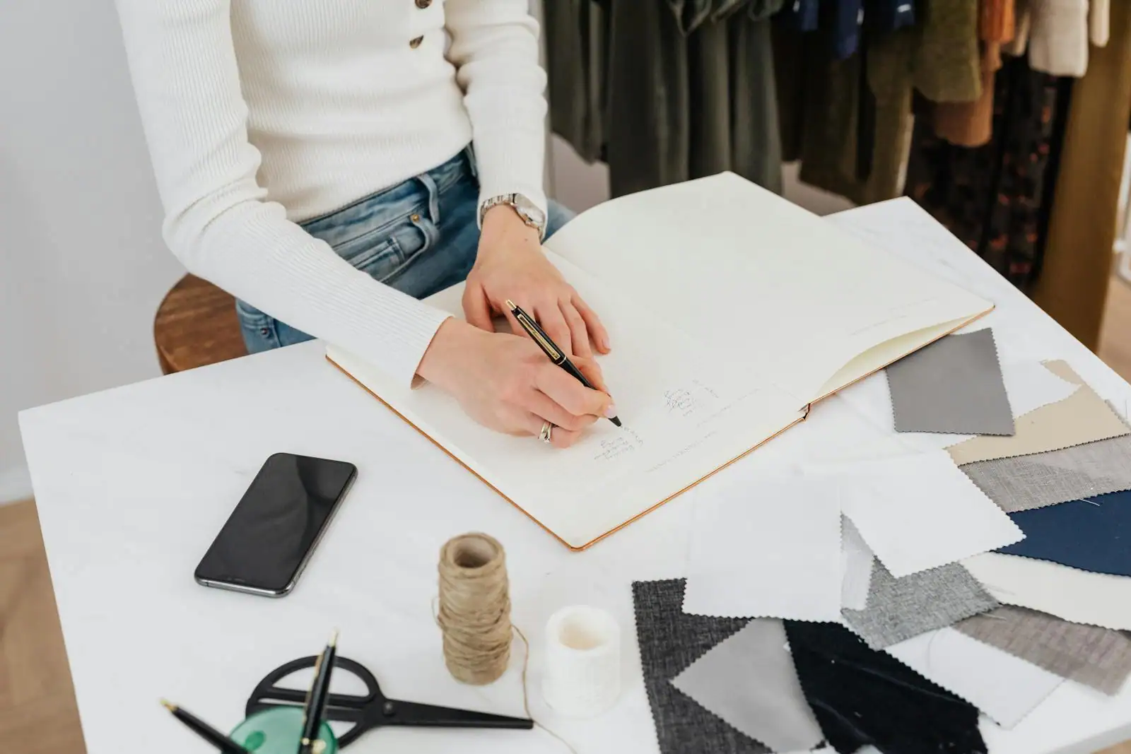Femme assise prenant des notes dans un carnet lors d'un atelier de développement personnel