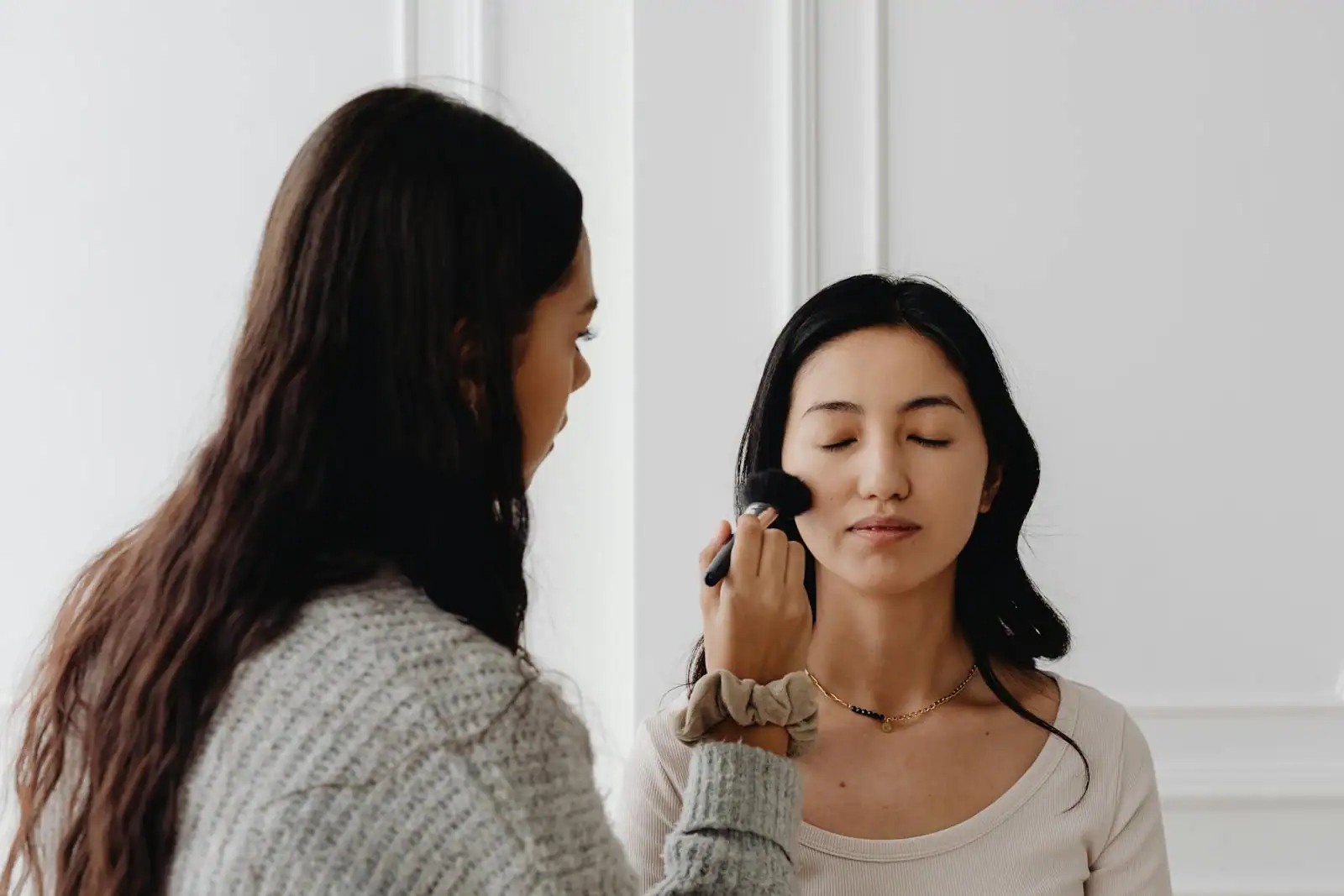 Application au pinceau d'un fond de teint liquide sur la peau du visage pour un teint lumineux
