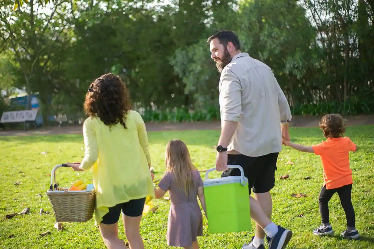 Une famille avec deux enfants en promenade dans un parc au soleil