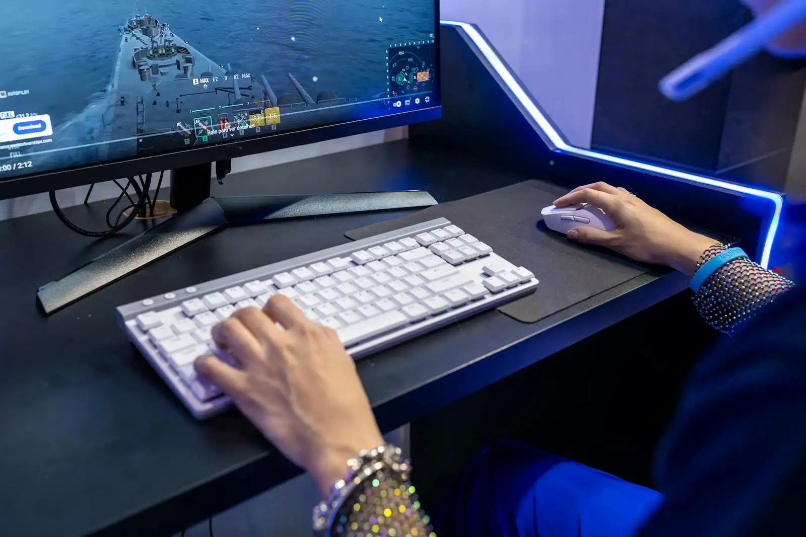 Personne joueuse devant un PC affichant un jeu de simulation de vie coloré