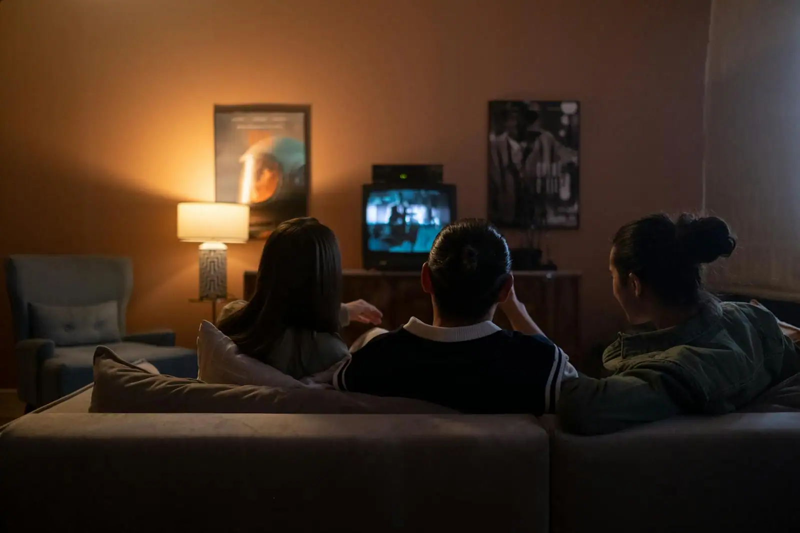 Salon cosy de soir avec télévision allumée et bougies, ambiance feutrée d'un visionnage entre amies
