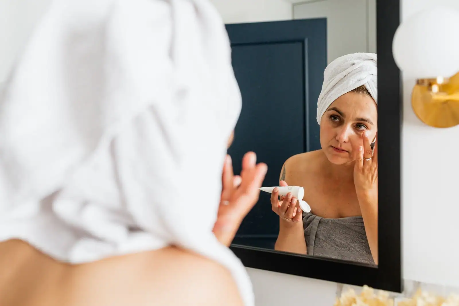 Femme appliquant une crème de soin sur son visage