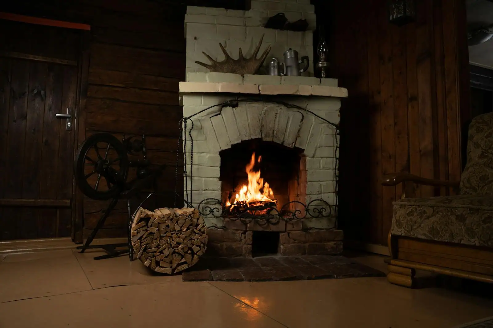 Feu de bois crépitant dans une cheminée, avec des bûches empilées à proximité dans un intérieur chaleureux