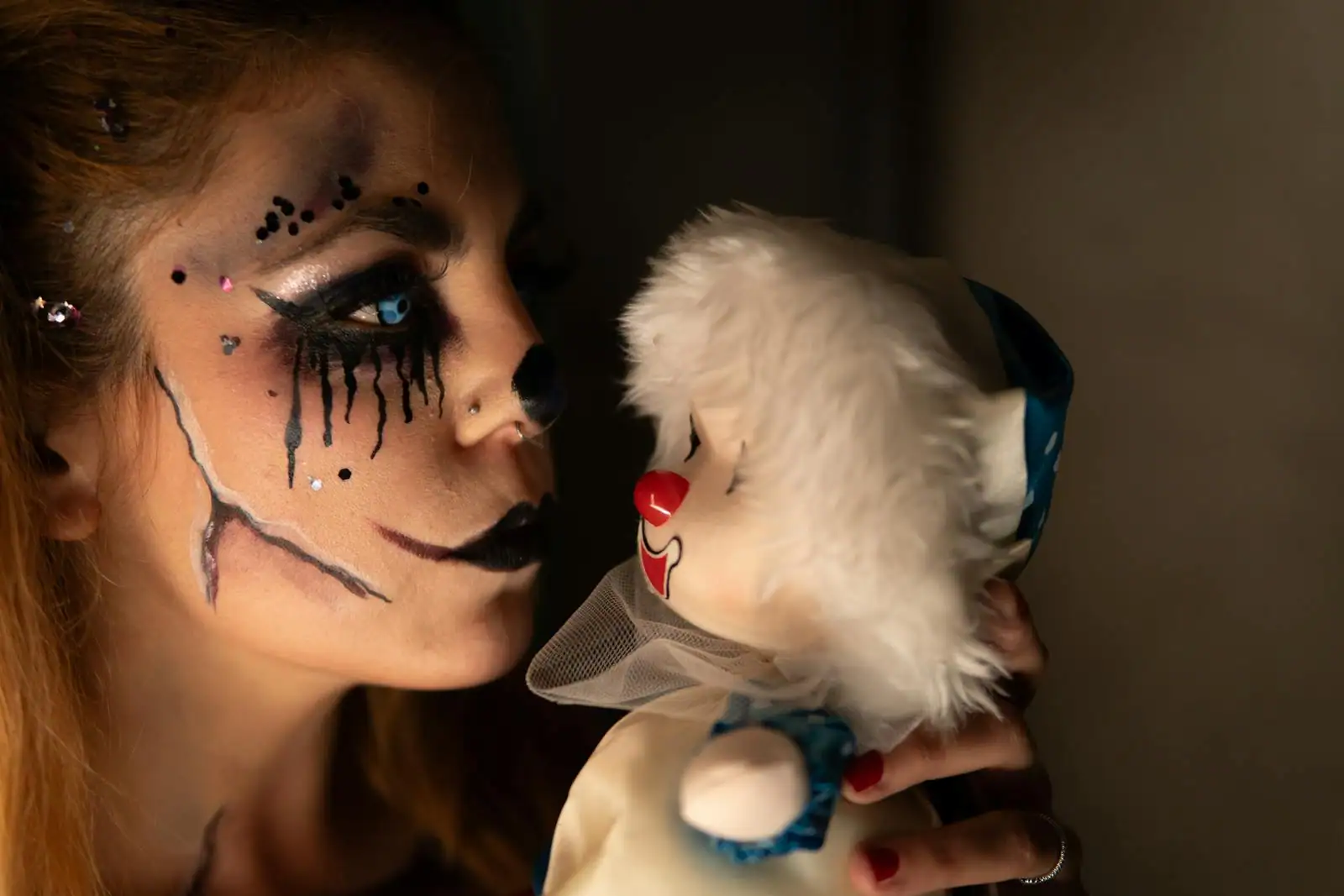 Maquillage de fête inspiré de Harley Quinn, yeux charbonneux étirés bleu et rose et bouche rouge vif en gros plan