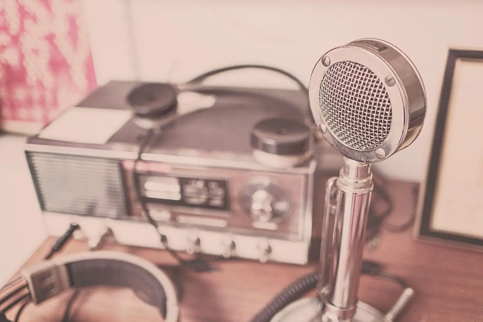 Poste de radio vintage, micro et casque audio posés sur une table en bois
