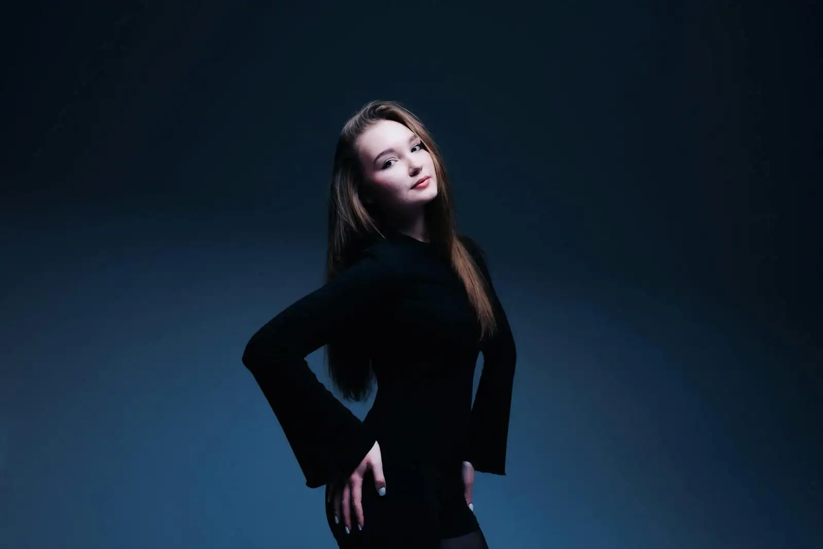 Jeune femme assurée en tenue noire élégante, portrait studio à l'éclairage soigné