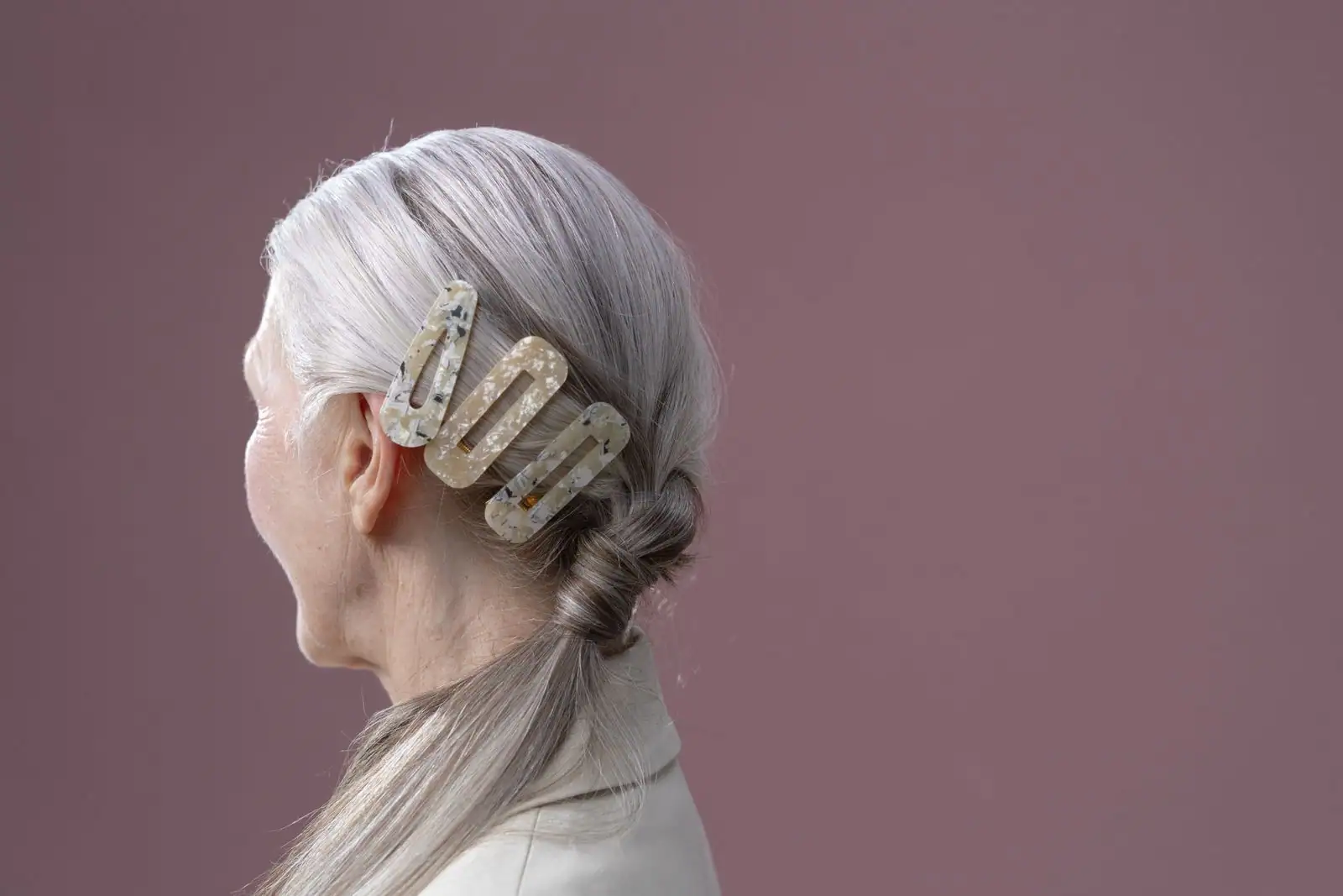 Femme aux cheveux gris argentés soignés, chevelure lumineuse vue de profil