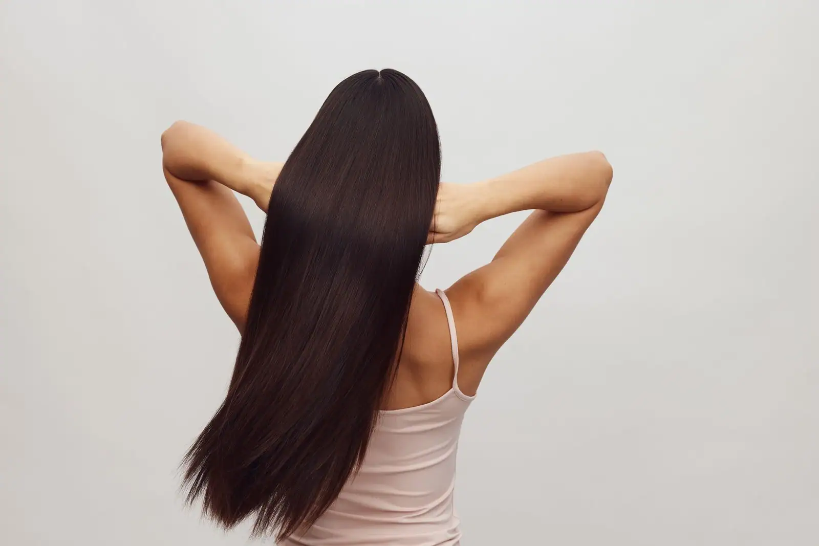 Longs cheveux bruns et lisses vus de dos, mettant en valeur les longueurs et les pointes