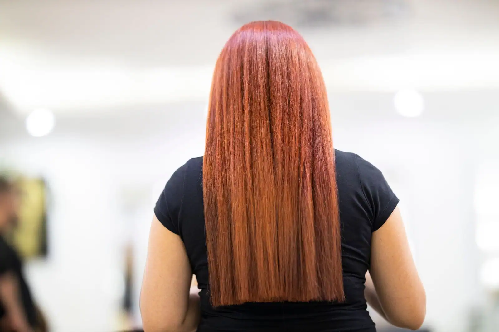 Femme lissant ses cheveux longs à la brosse, pointes disciplinées