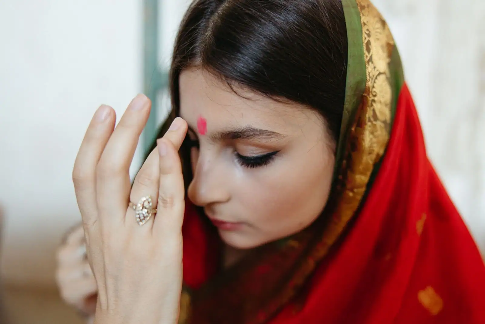 Jeune femme au voile rouge, œil souligné d’un trait noir et bindi rouge posé entre les sourcils