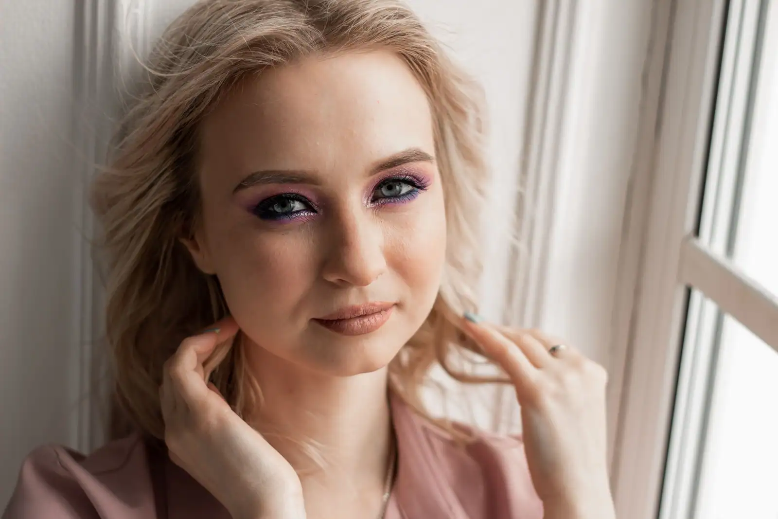 Maquillage des yeux dans les violets, paupière nacrée et rappel de couleur sous l’œil, bouche discrète