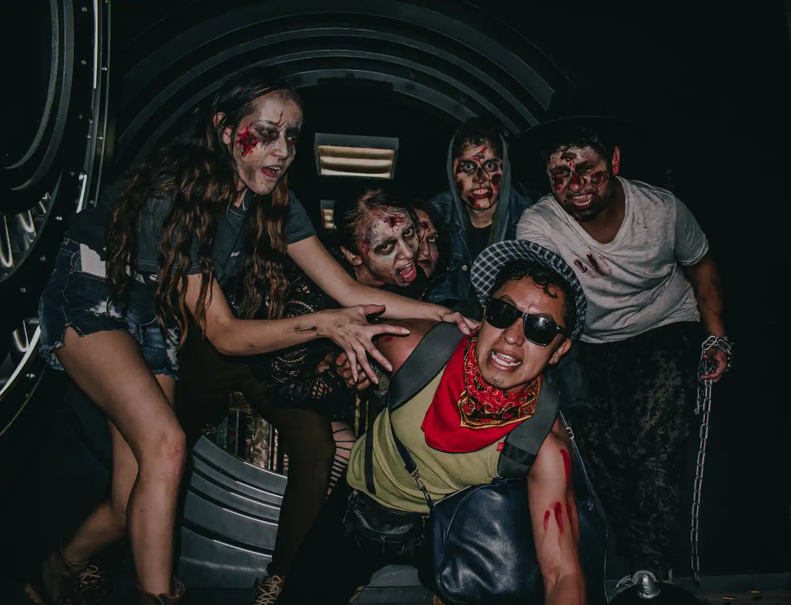 Groupe maquillé en zombies pour Halloween : teints blafards, yeux creusés et taches de faux sang